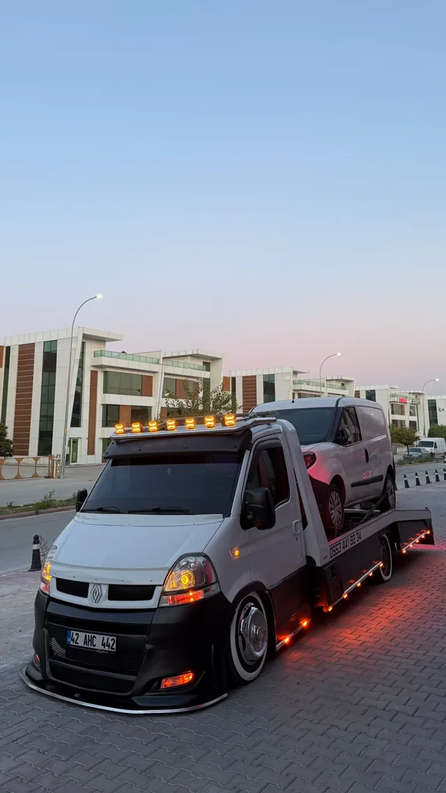 Kayar kasa çekicinin üstünde taşınan beyaz hafif ticari araç
